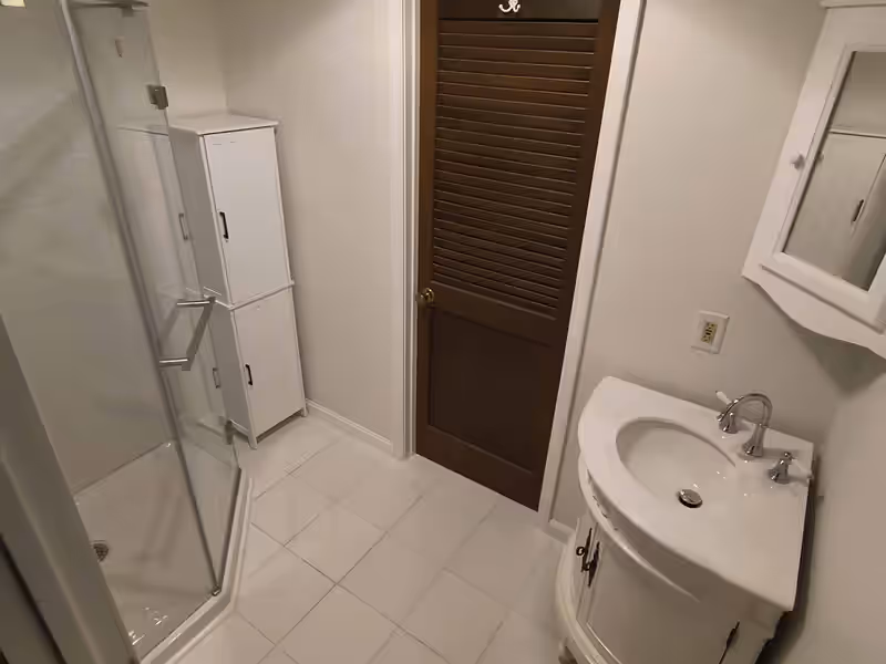 Finished bathroom remodel with tiled floor, corner glass shower and new vanity by Empirical Renovations in Vermont