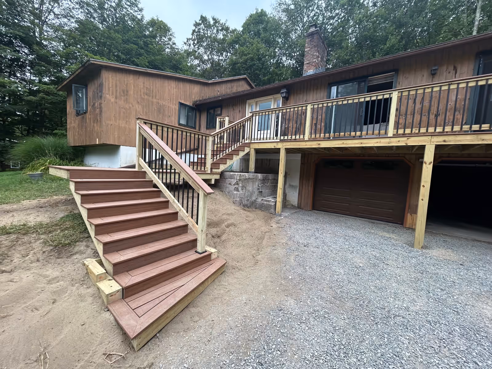 The same Essex VT home after Empirical Renovations rebuilt the deck, with wide stairs, new decking and pressure-treated railings