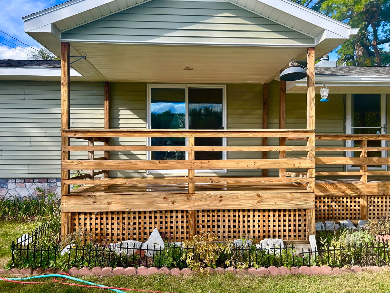 The same porch railing after deck power washing by Empirical Renovations, back to clean bright wood