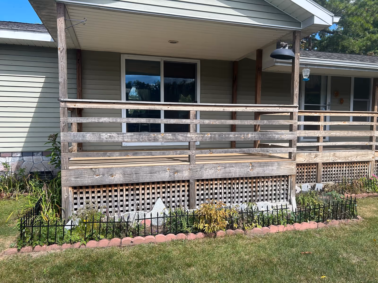 Weathered gray porch railing and lattice before pressure washing at a Vermont home