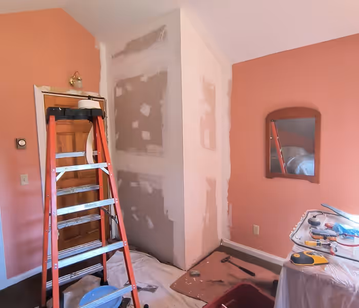 Newly drywalled chimney chase taped and mudded ready for paint in a Vermont bedroom by Empirical Renovations