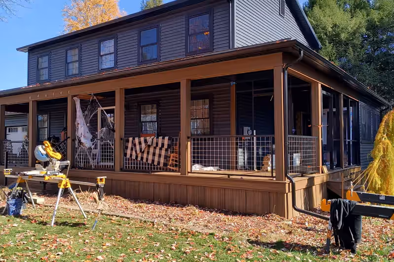 Covered porch running the full width of a Vermont home and turning the corner, built by Empirical Renovations