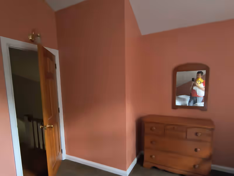 Bedroom repainted in terracotta with crisp white trim and ceiling by Empirical Renovations in Vermont