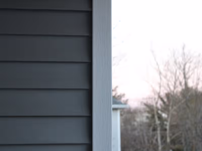 Charcoal lap siding meeting a light grey corner board on a newly sided Vermont home by Empirical Renovations
